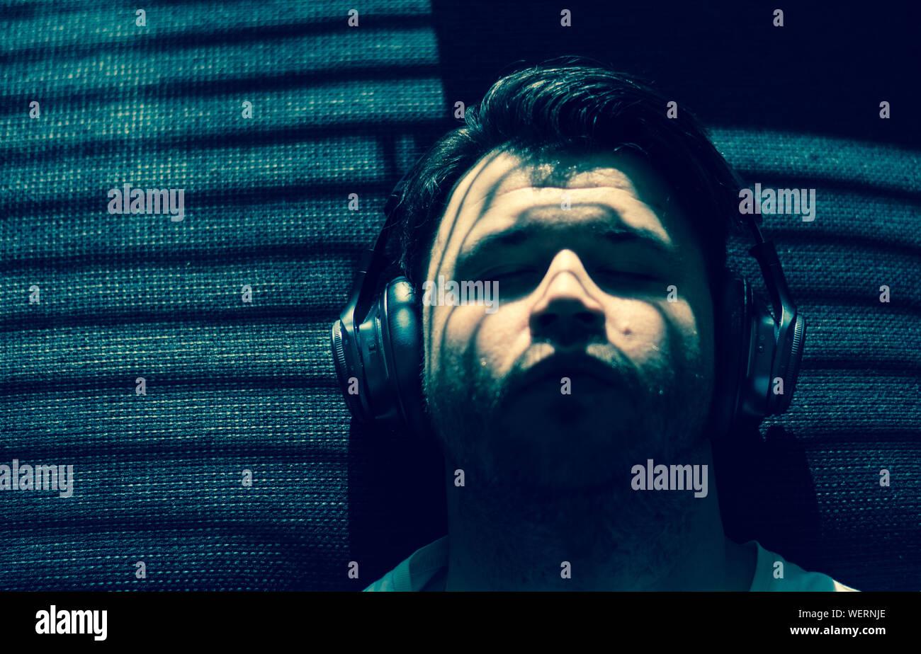 Man listening music lying on hi res stock photography and images