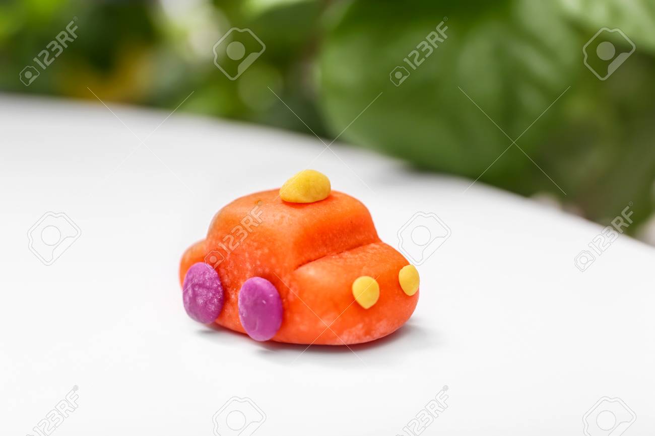 Car Made From Playdough On Table Against Blurred Background