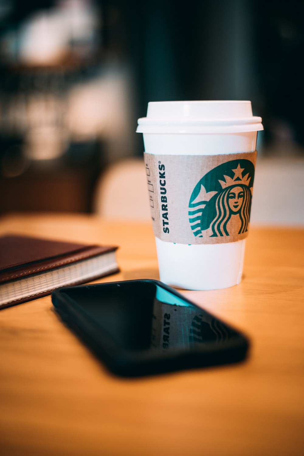 Black Smartphone Beside A White Starbucks Cup Photo Coffee