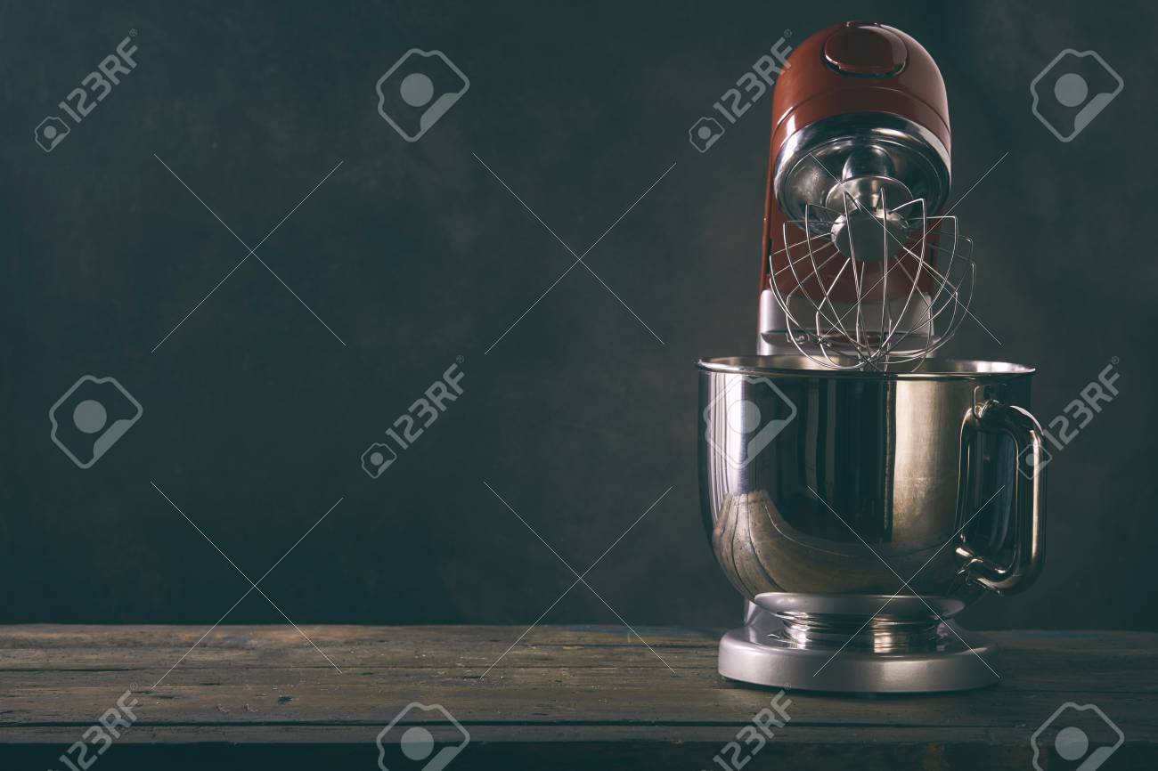 Kitchen Mixer Standing On Wooden Countertop Against Dark