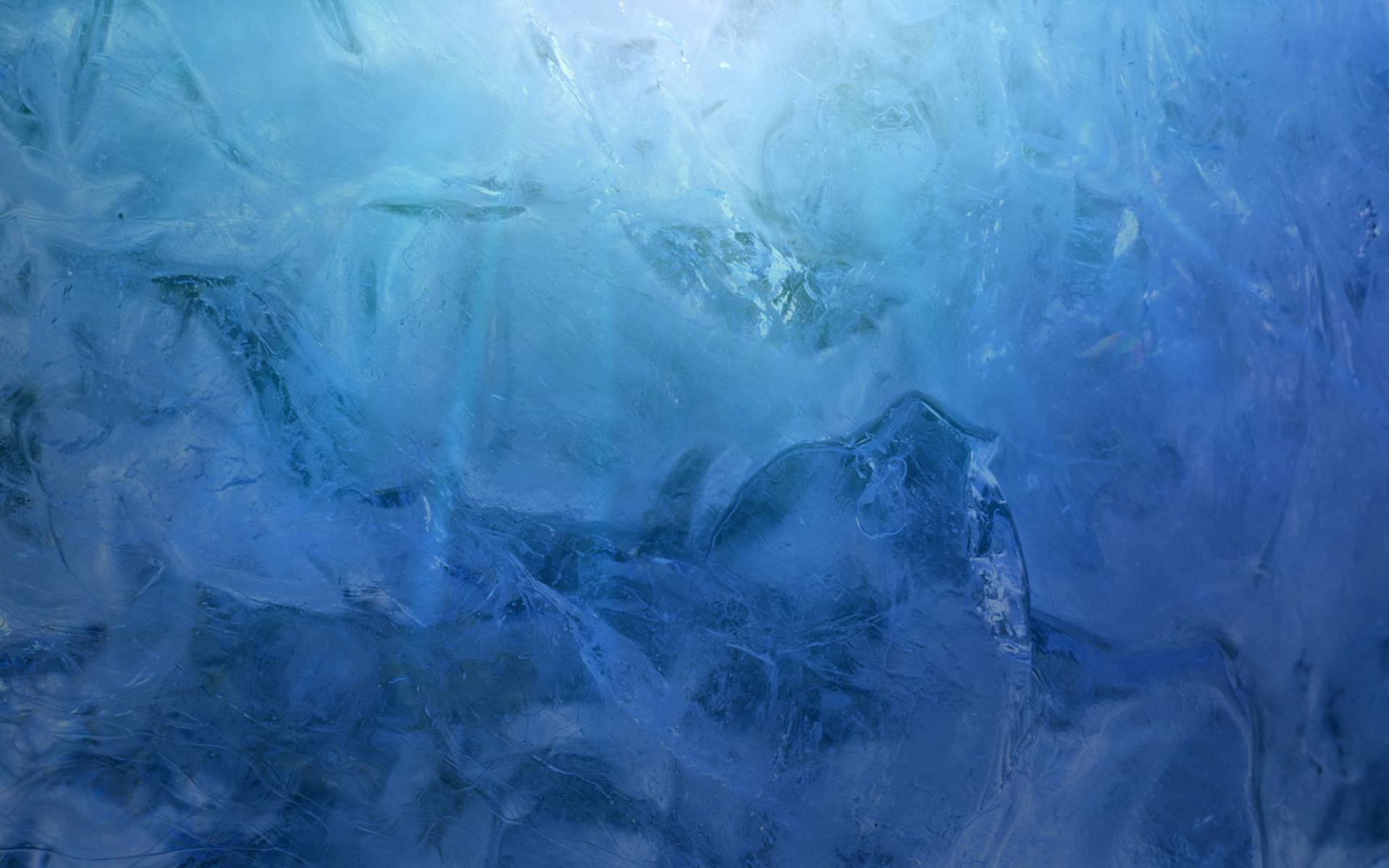 Close-up of a textured ice surface with varying shades of blue, highlighting the natural patterns and formations within the frozen water