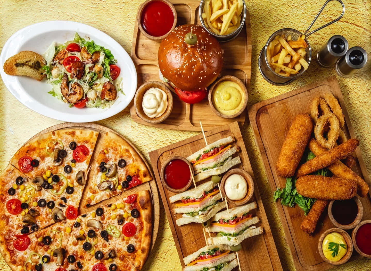 A Pizza Fries And Other Food On Wooden Table Wallpaper
