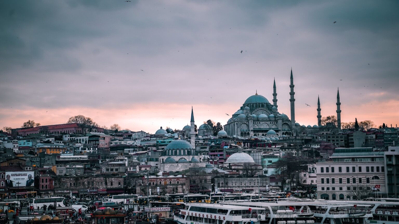 A picturesque view of the Istanbul skyline at sunset, featuring the Süleymaniye Mosque and the Bosphorus Strait
