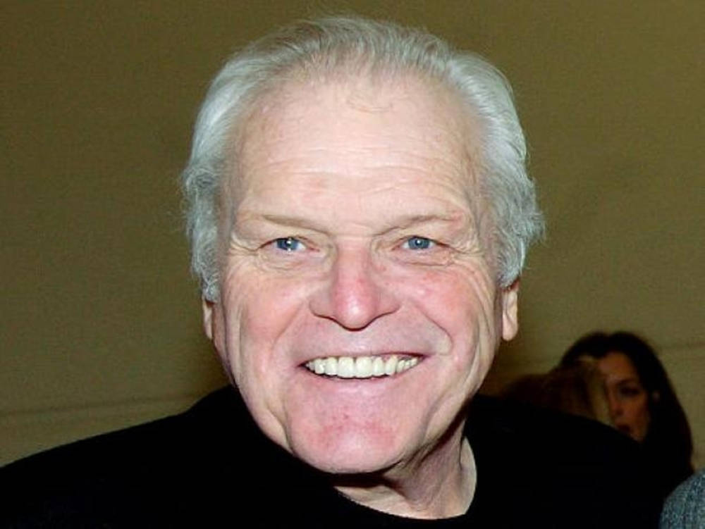 Brian Dennehy Smiling On Brown Wallpaper