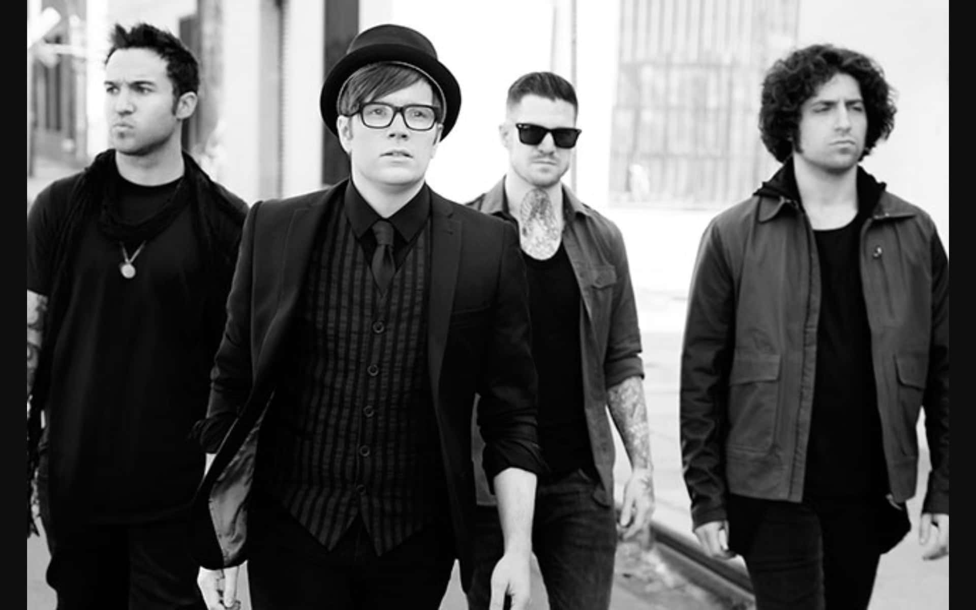A black and white photo of the band Fall Out Boy walking down a street
