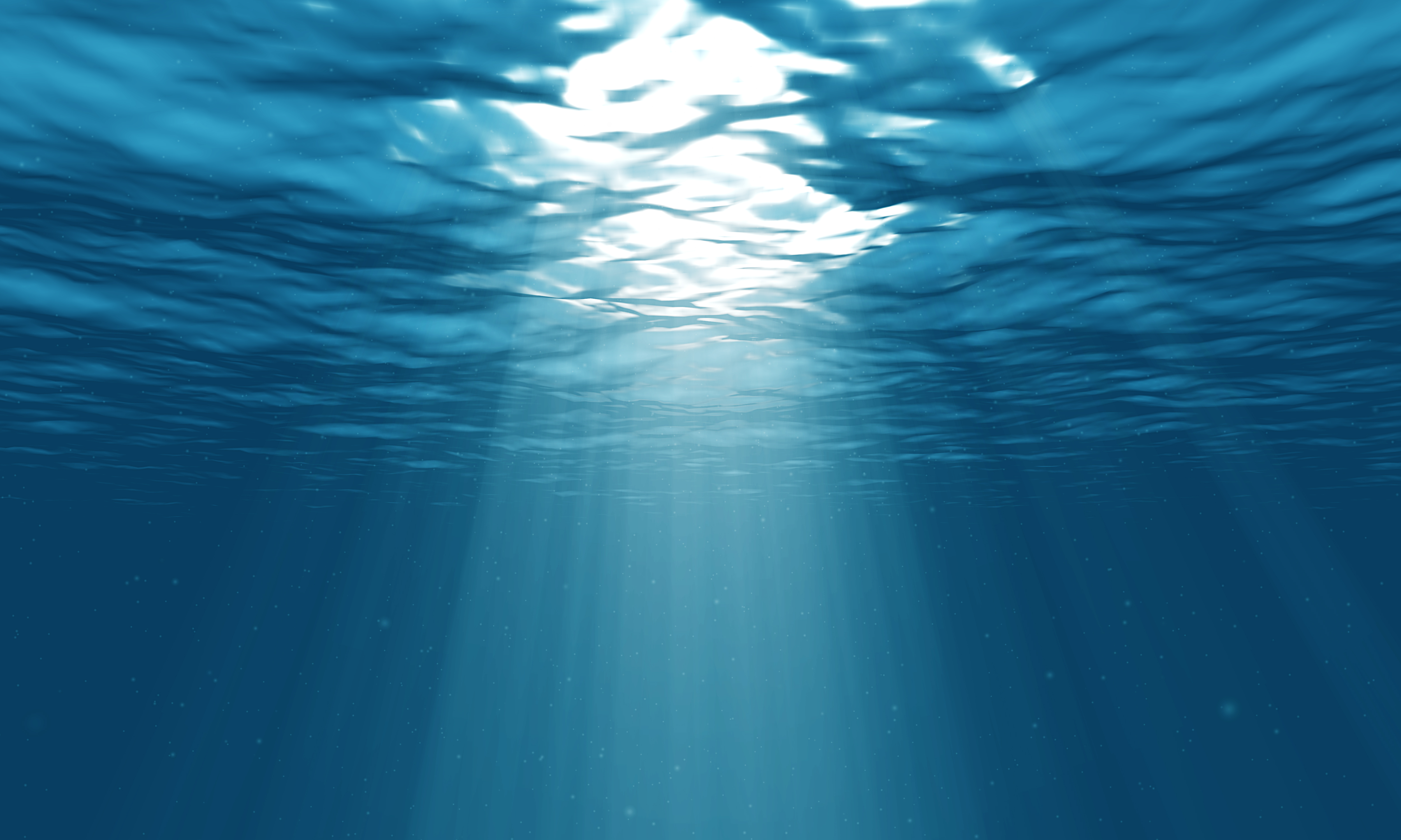 Sunlight piercing through the surface of a serene, deep blue ocean, creating mesmerizing beams of light underwater. 4K resolution