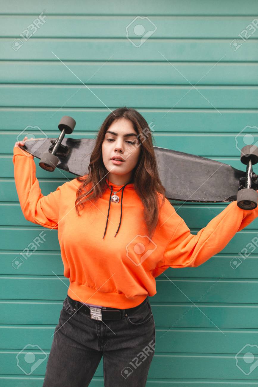 Portrait Of An Attractive Girl In Bright Streetwear Stands On