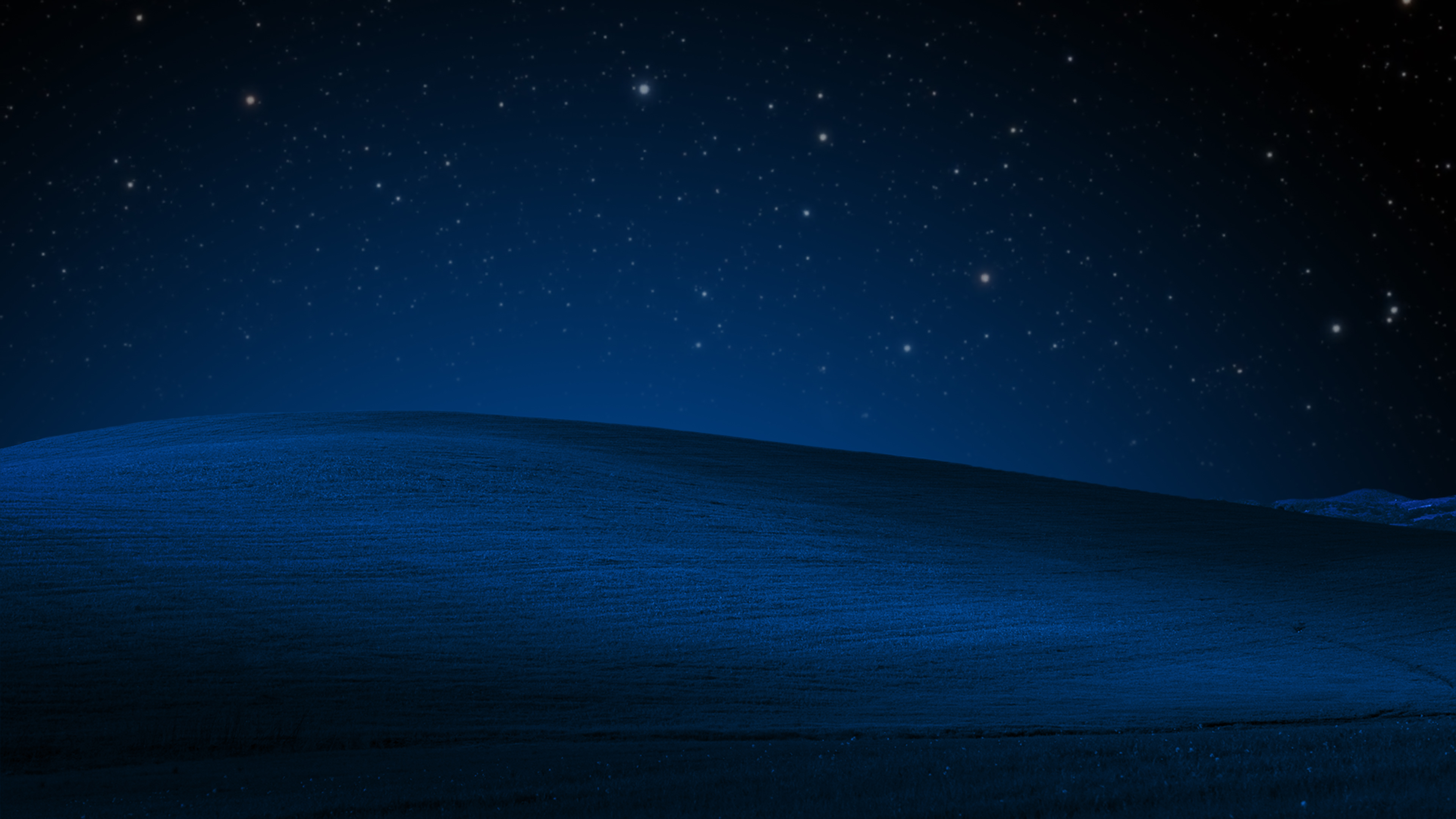 A serene, dark blue, rolling hill under a night sky filled with stars. Reminiscent of the classic Windows XP 'Bliss' wallpaper, this image evokes a sense of calm and wonder.  Ideal for a desktop background