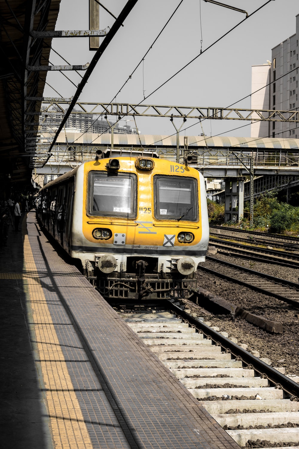 yellow and black train on rail tracks during daytime photo Free