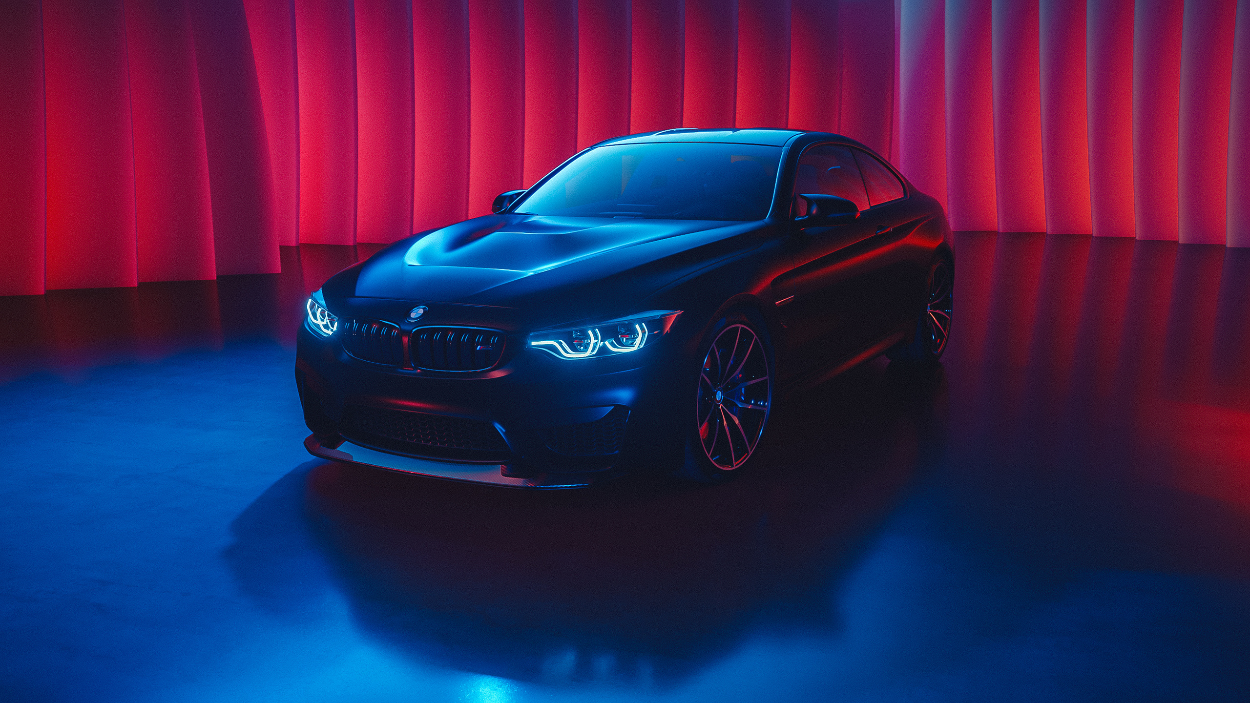 Sleek black BMW sports car on a vibrant, neon-lit stage