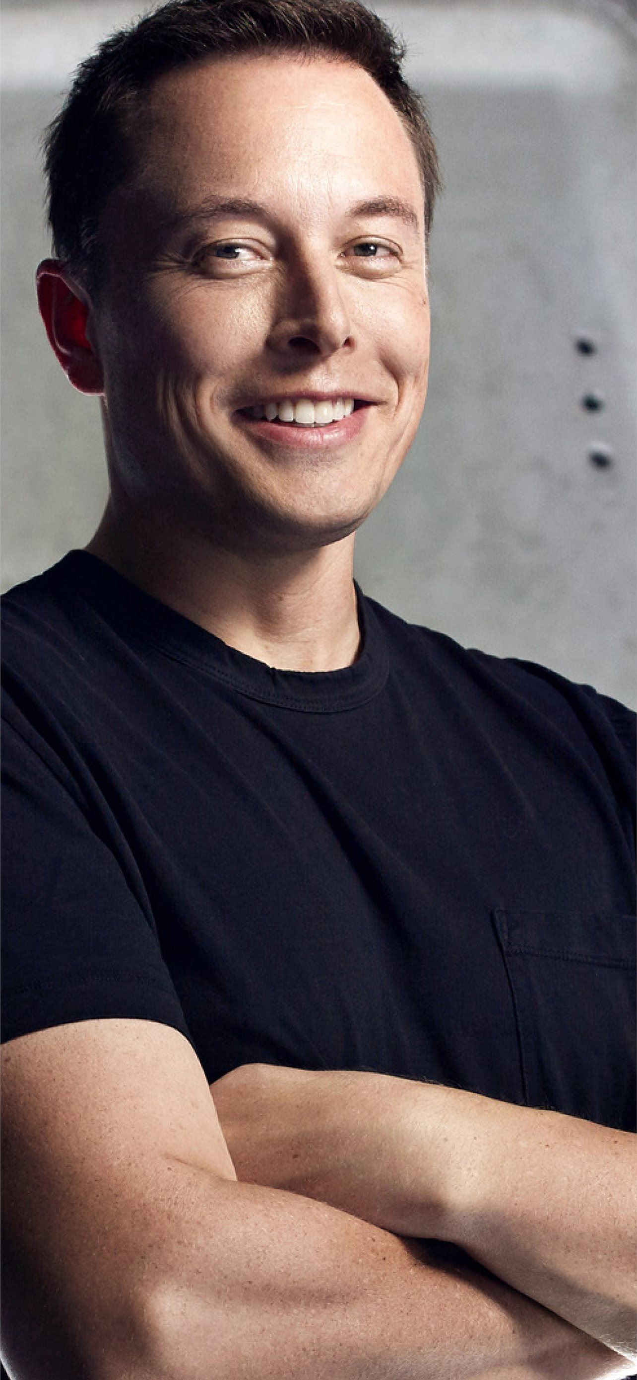 Elon Musk, CEO of Tesla and SpaceX, smiles with arms crossed in a close-up portrait