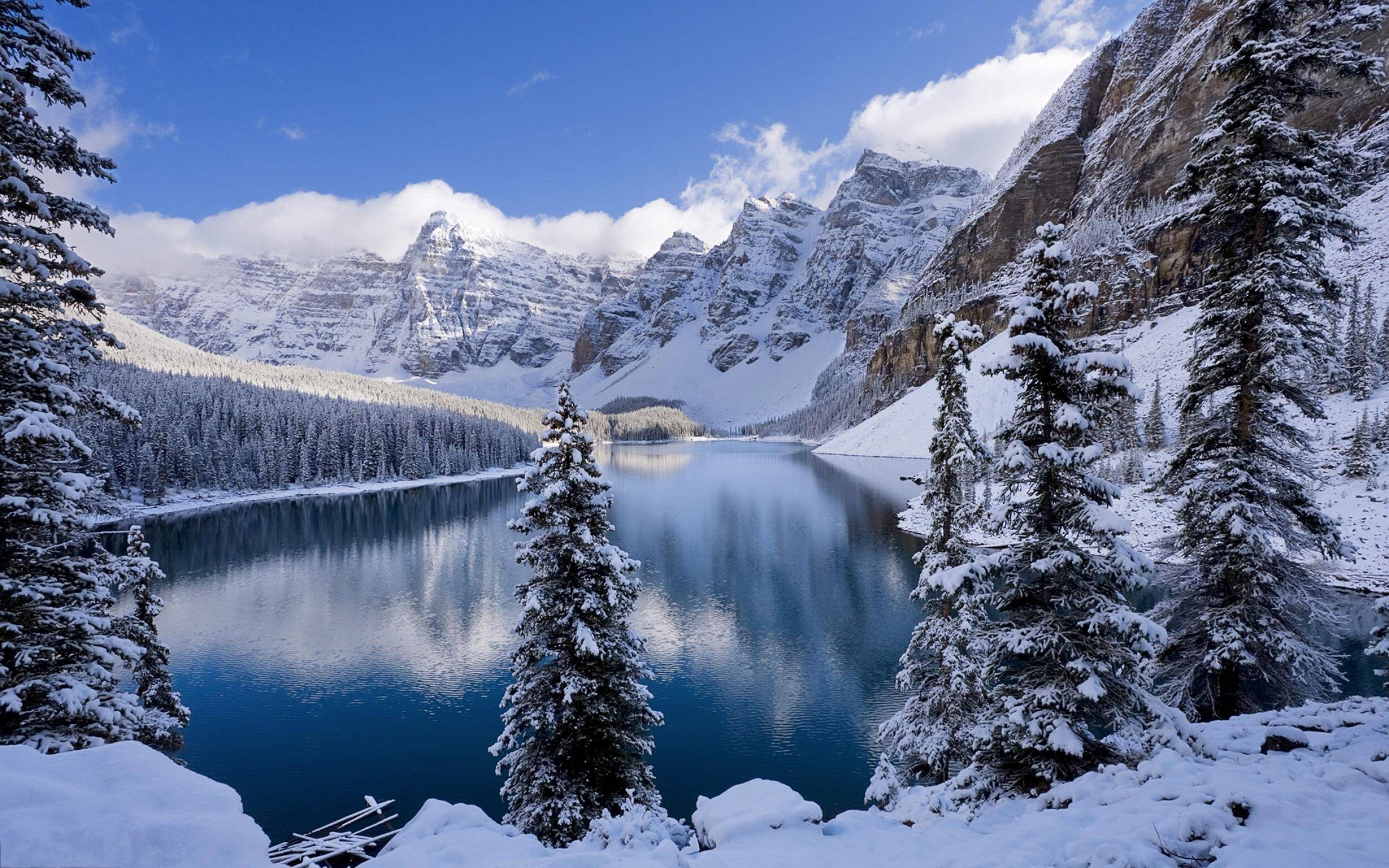 Serene winter landscape with snow-covered mountains and a pristine lake