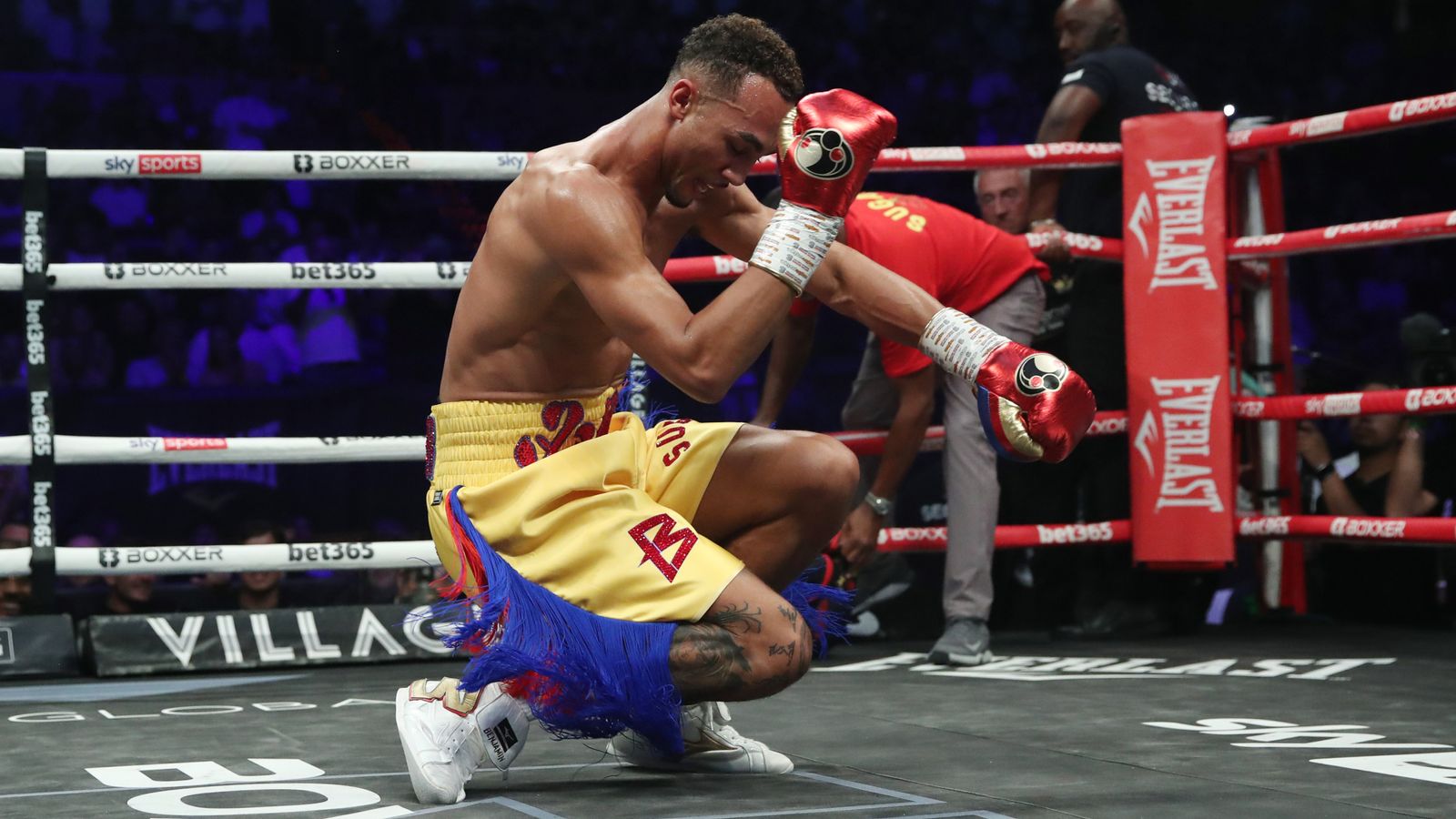 Benjamin Whittaker kneeling in victory after a boxing match