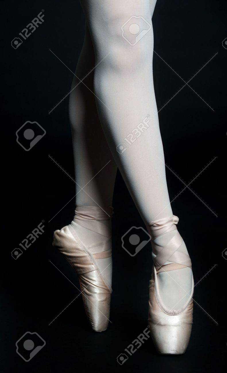 A Pair Of Slender Ballerina Legs On Tip Toe Against Black