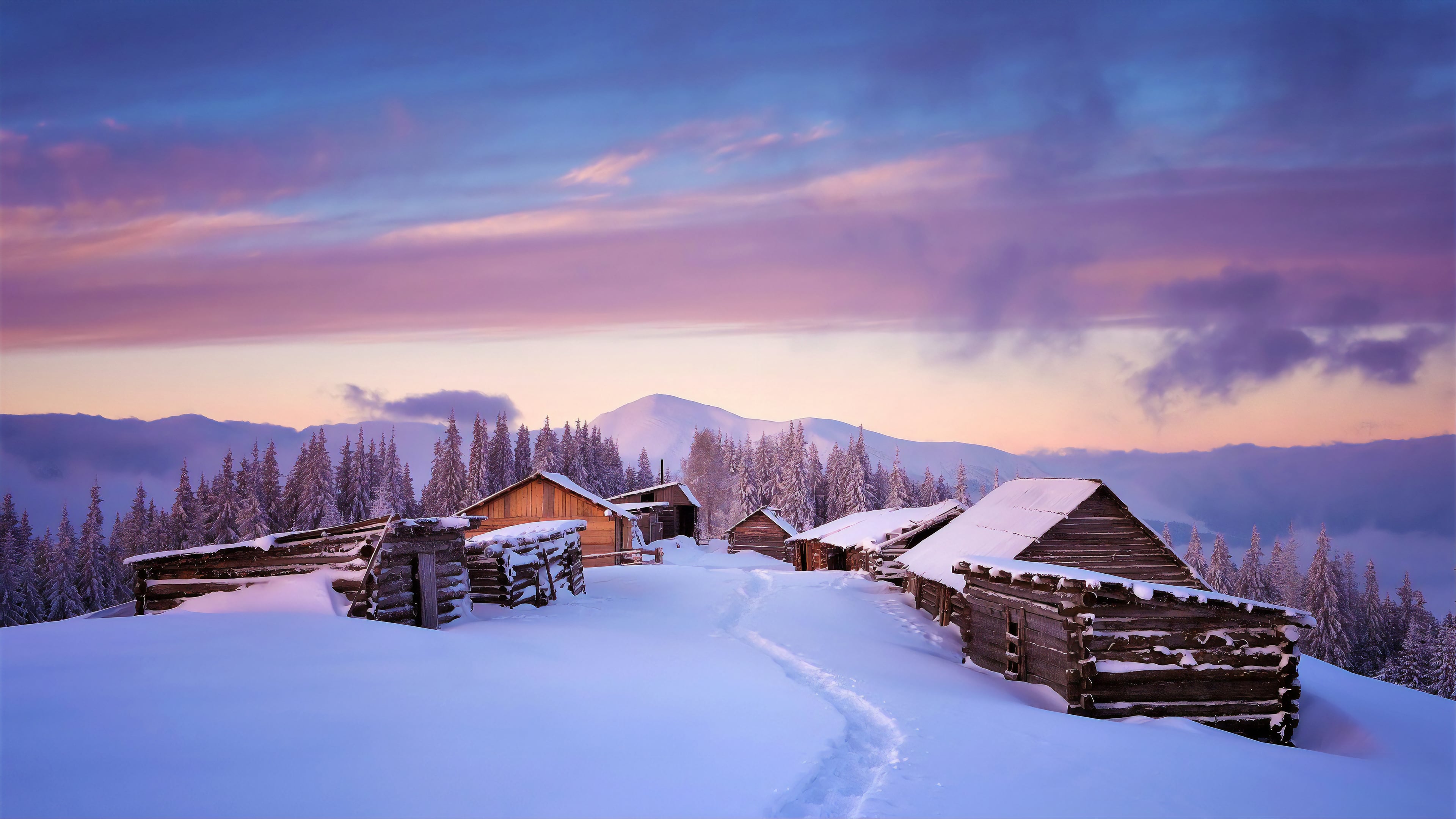 4k wallpaper of a snow-covered village nestled in a mountain valley during a breathtaking winter sunset