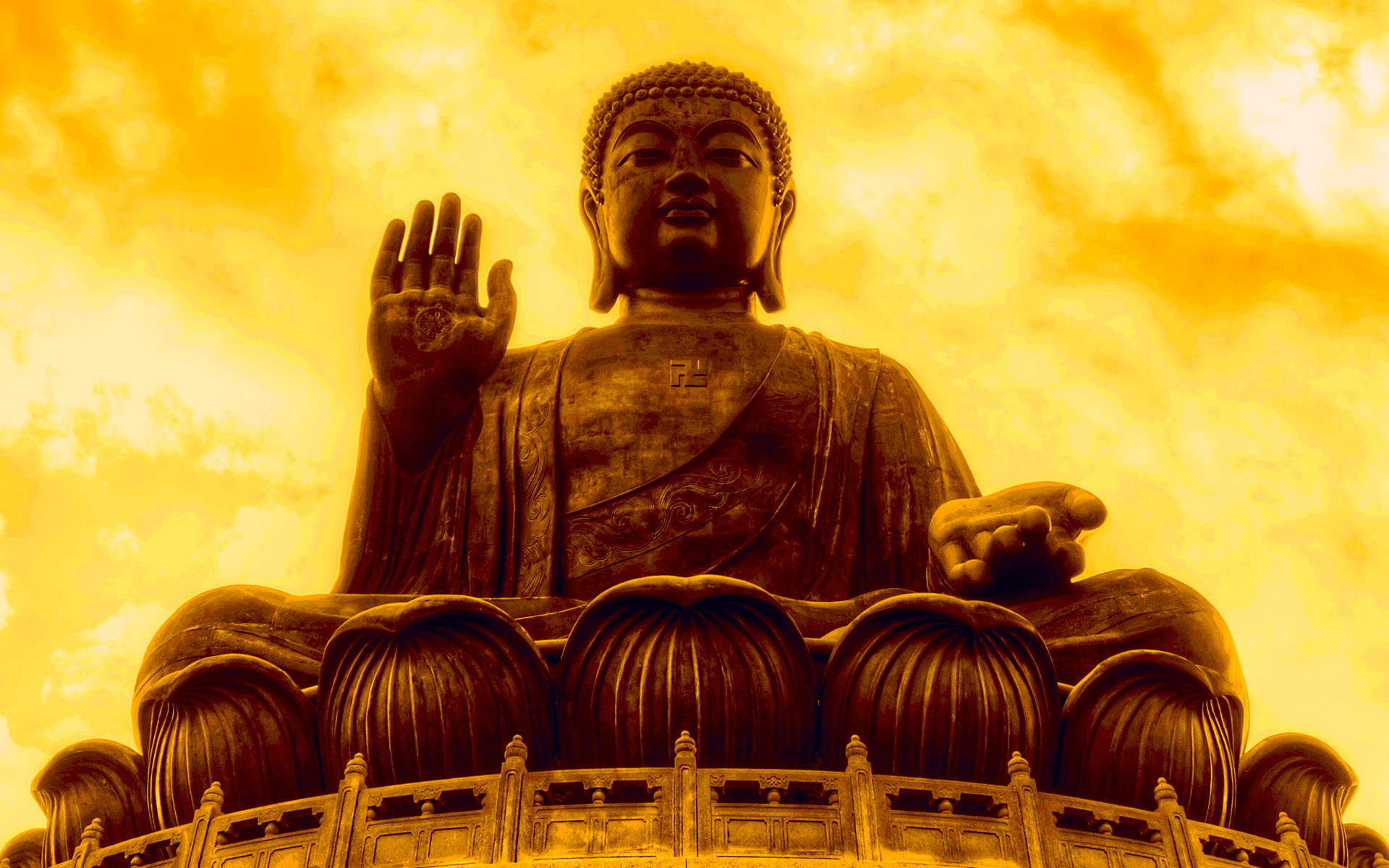 A majestic golden statue of Buddha against a vibrant sunset backdrop