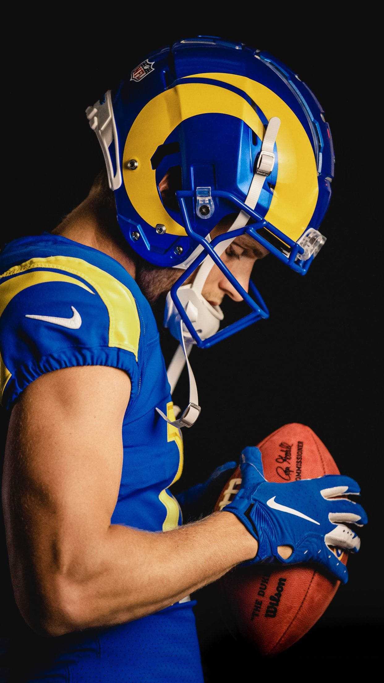 A Los Angeles Rams player in full uniform, holding a football