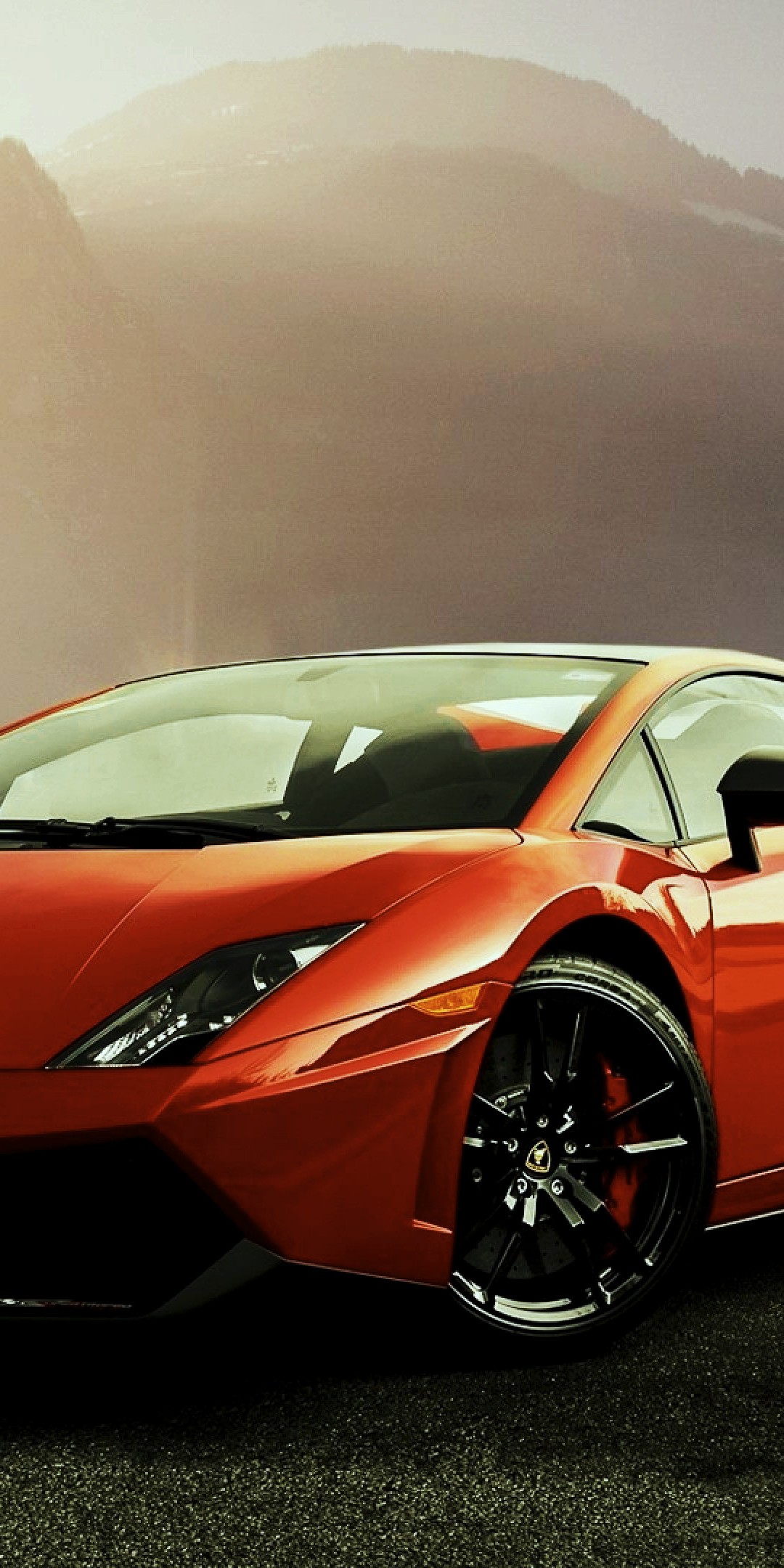 Red Lamborghini Gallardo parked on a road with mountains in the background