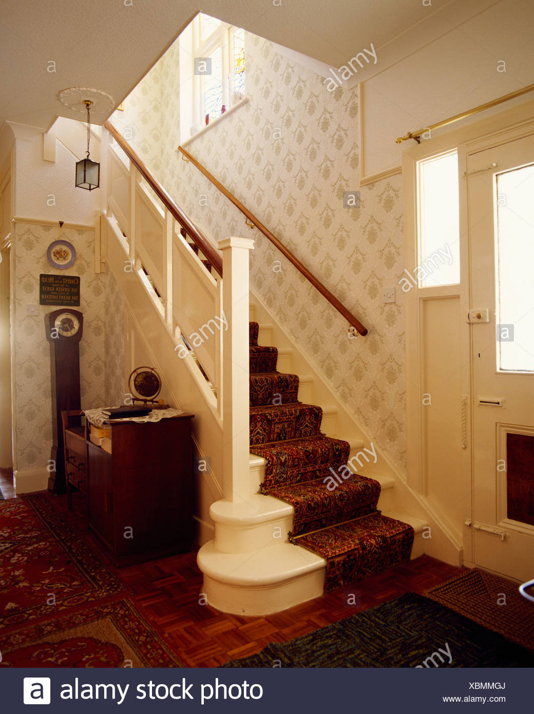 Forties Hall And Cream Staircase With Patterned Wallpaper Stock