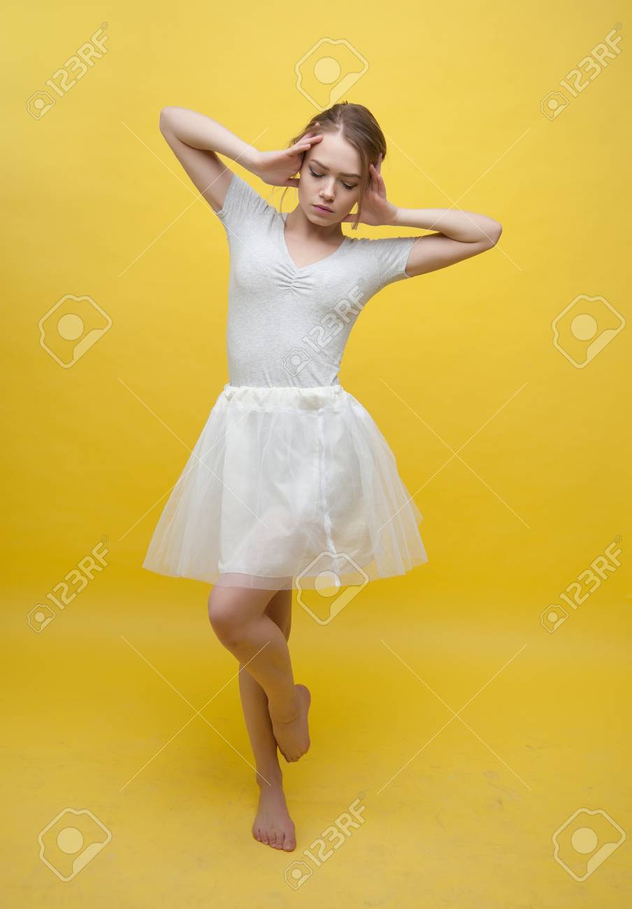 Barefoot Girl Dancing Ballet On A Yellow Background Stock Photo