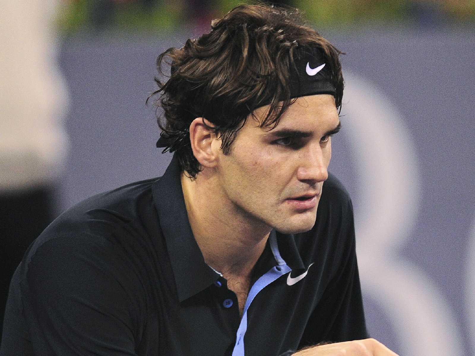 Photo Of Our Tennis Star With A Dark Blue Polo Shirt And Nike Headband
