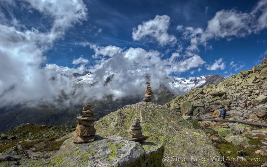 Stacked Stones Along The Hiking Path Aletsch Wallpaper Cover