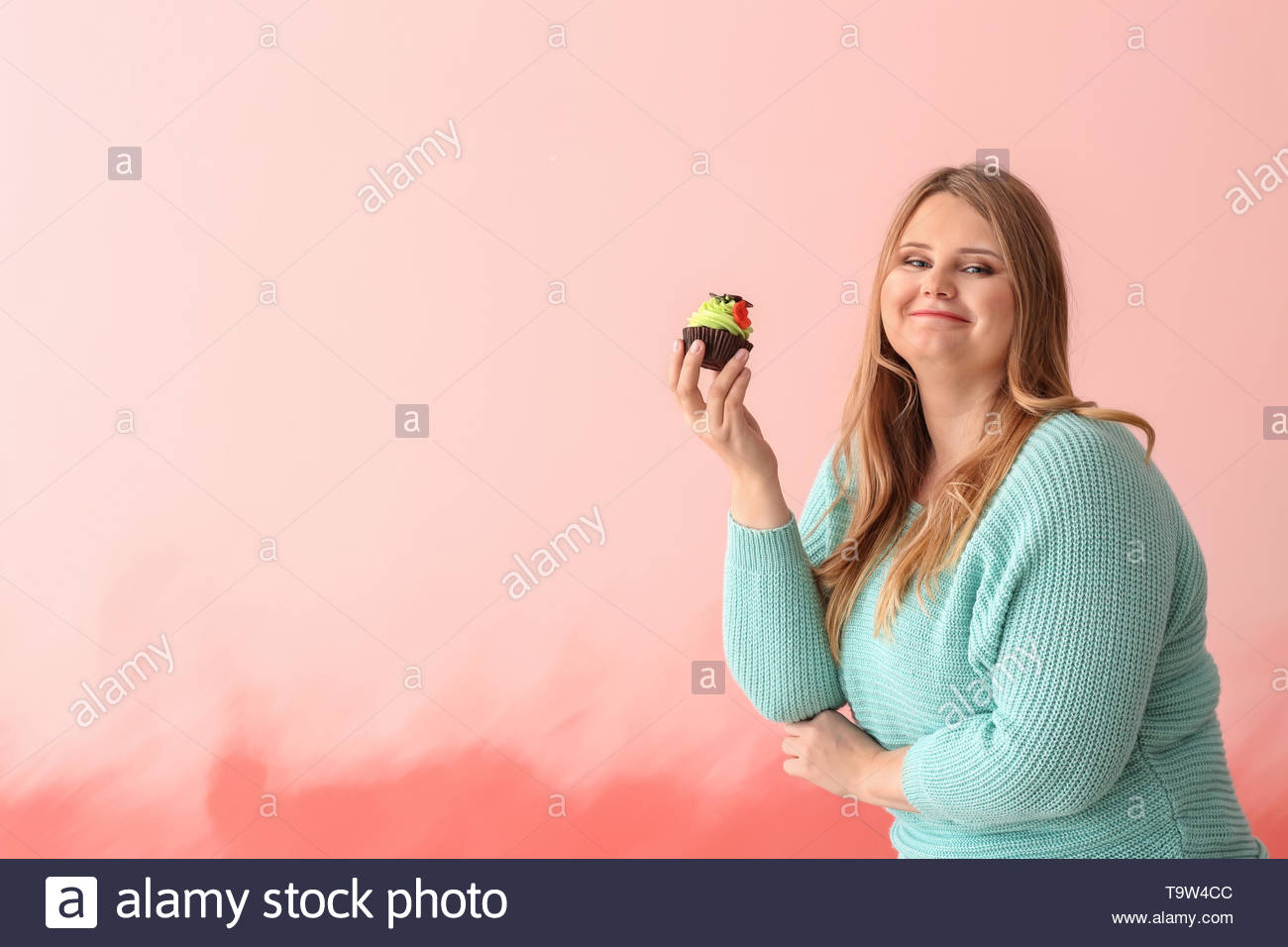 Happy Plus Size Girl With Sweet Cake On Color Background Concept