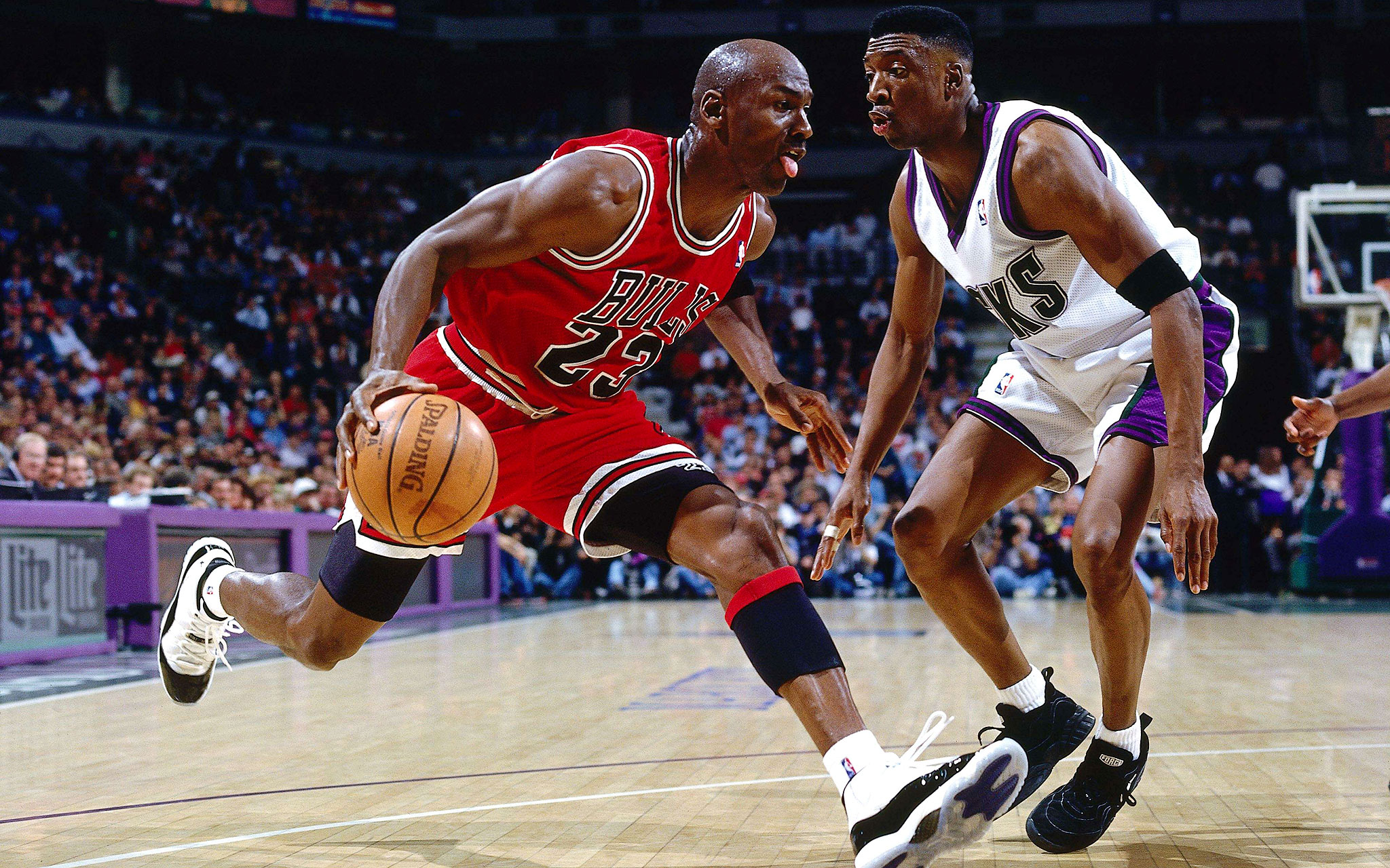Michael Jordan dribbling the ball during an NBA game, wearing a Chicago Bulls jersey