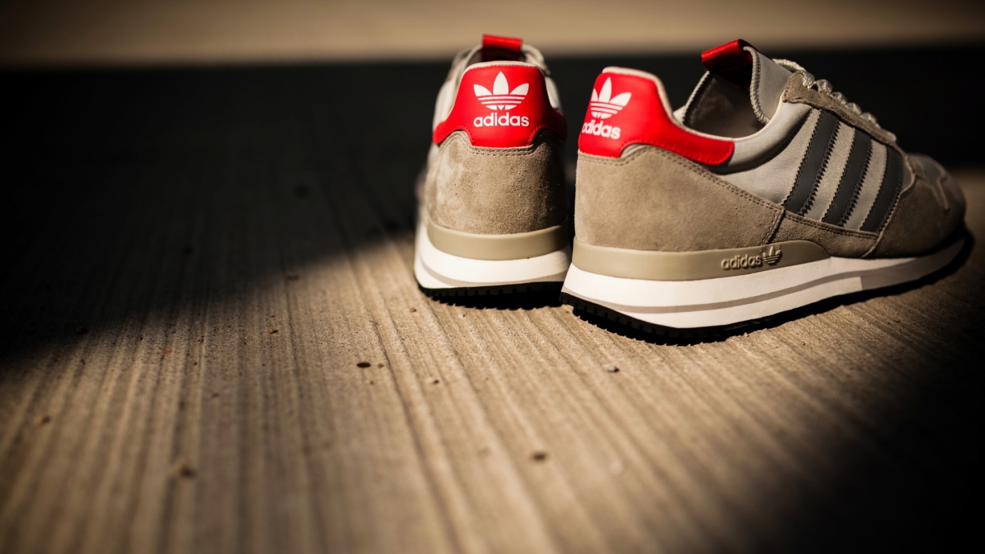 Pair of Adidas sneakers on a wooden surface