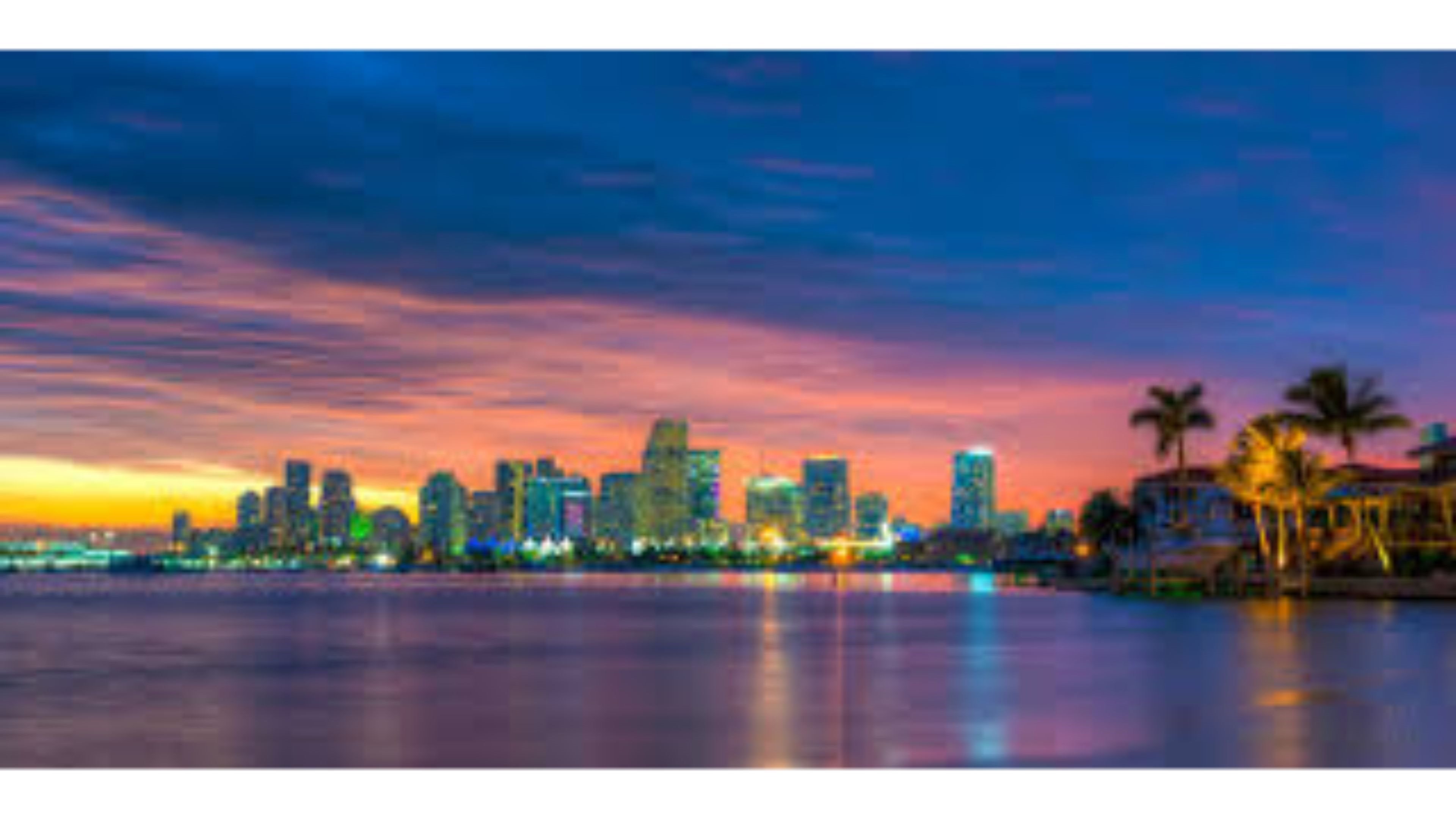 Miami skyline at sunset with vibrant colors reflecting in the water