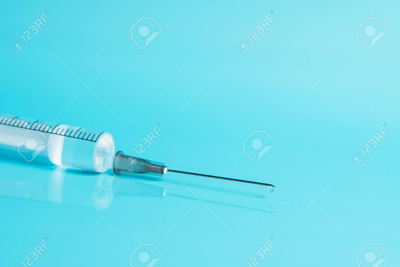 Syringe With Medicine On A Blue Background Medication And