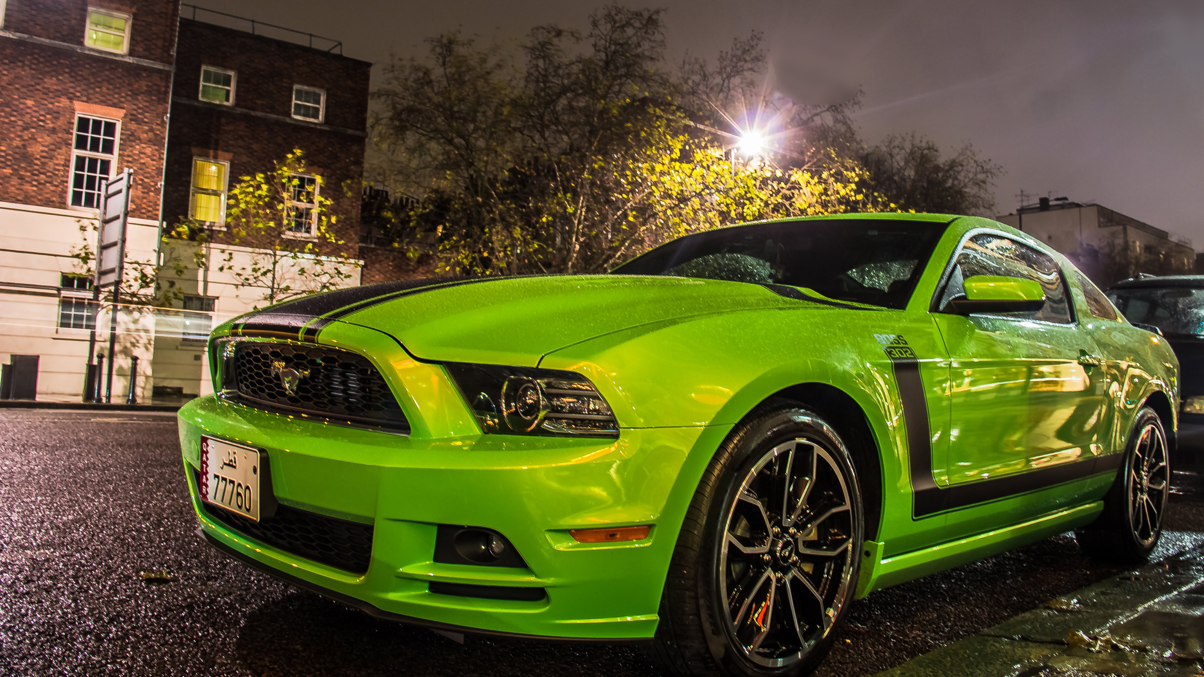 Bright Green Ford Mustang Boss 302 parked on a city street at night
