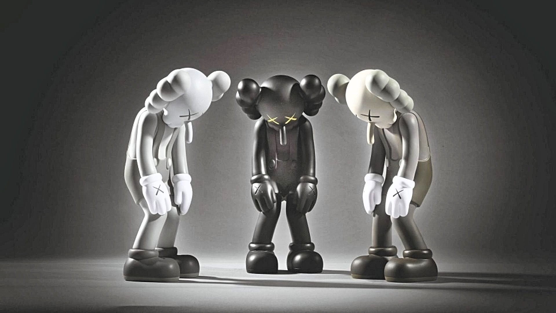 Three KAWS Companion figures in different colorways, standing with their heads down in a melancholic pose