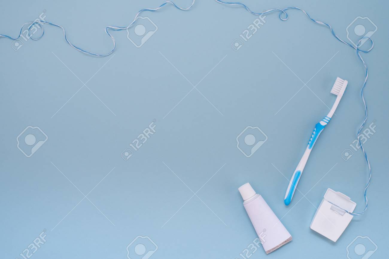 Toothbrush Toothpaste And Dental Floss On A Light Blue Background