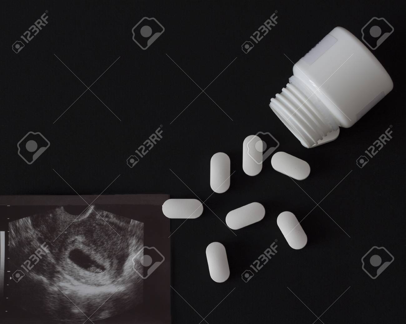 A Shot Of Uzi Pregnancy And Pills With Jar Black Background