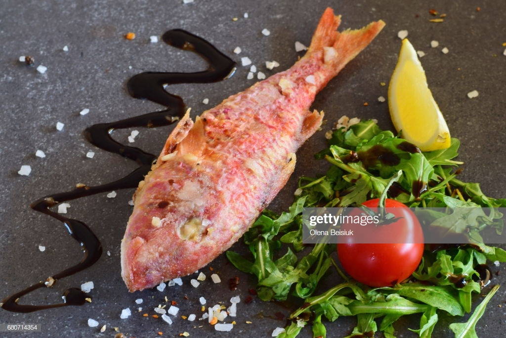 Grilled Red Mullet On A Greay Abstract Background With Rokka Salad