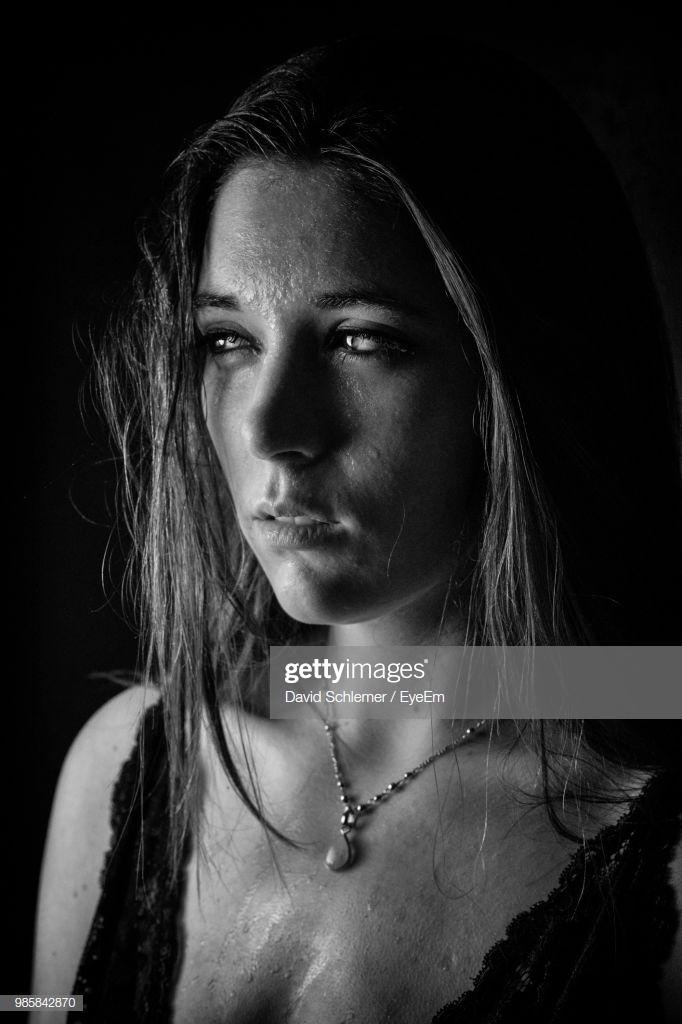 Closeup Of Woman Crying Against Black Background High Res Stock