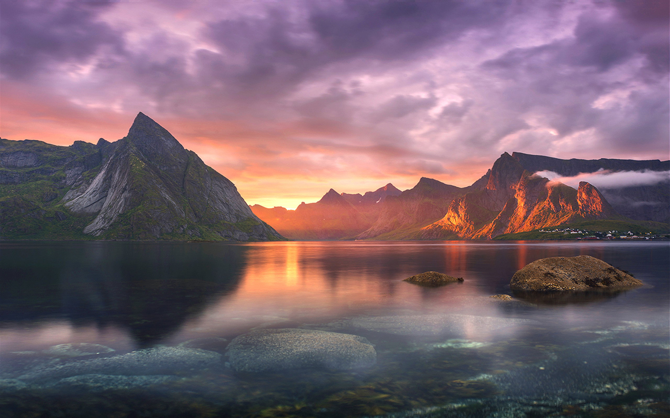 A breathtaking sunset over a serene fjord in Norway, with majestic mountains reflecting in the calm water. Perfect for a MacBook wallpaper