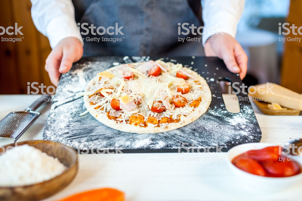 Closeup Of Raw Homemade Traditional Italian Pizza In Chef Hands