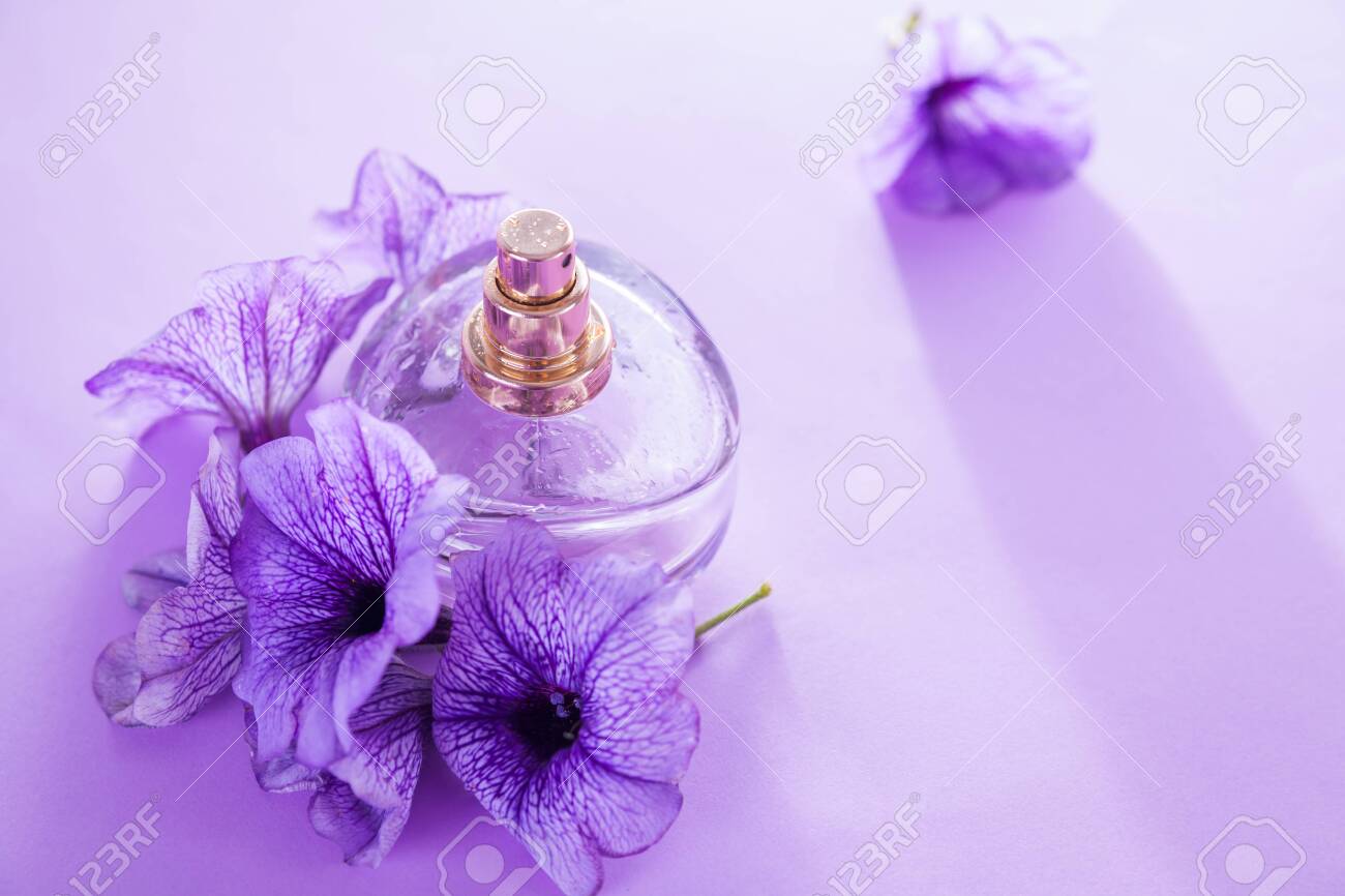 Bottle Of Perfume With Flowers On Purple Background Floral