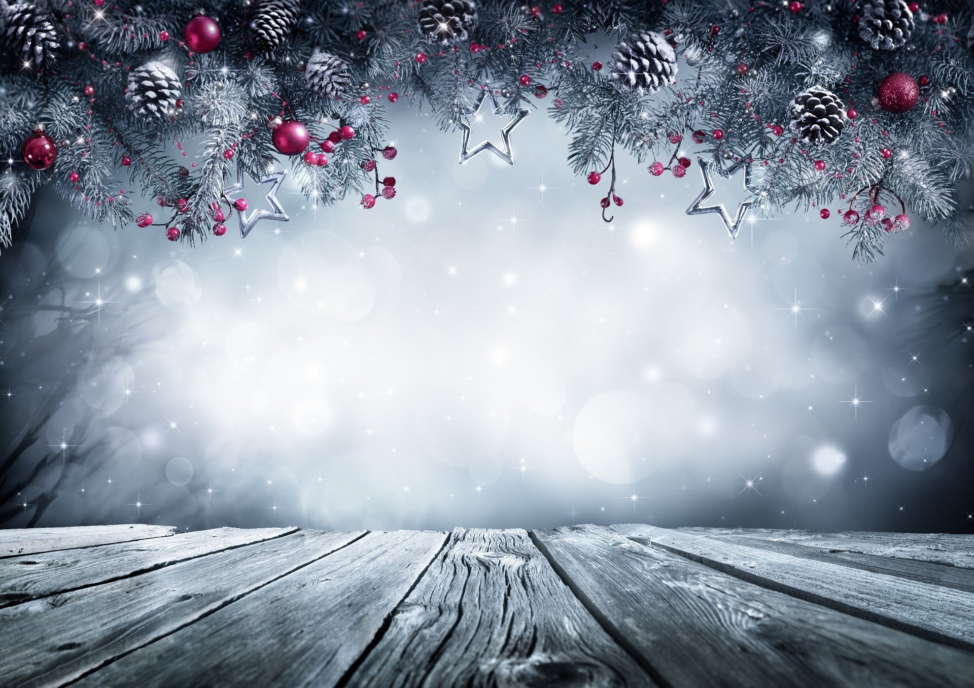 Christmas background with snowy fir branches, red berries, silver star ornaments, and a rustic wooden table. Perfect for holiday greetings or festive website banners