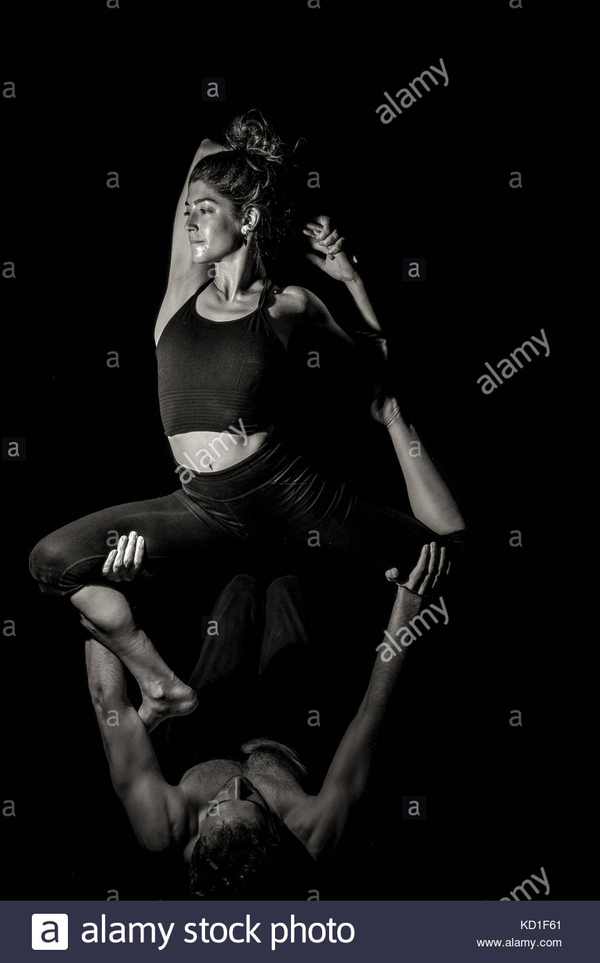 Couple In Acroyoga Position On Black Background With Single Light