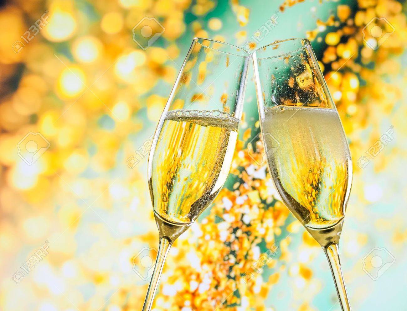 A Pair Of Champagne Flutes With Golden Bubbles Make Cheers On