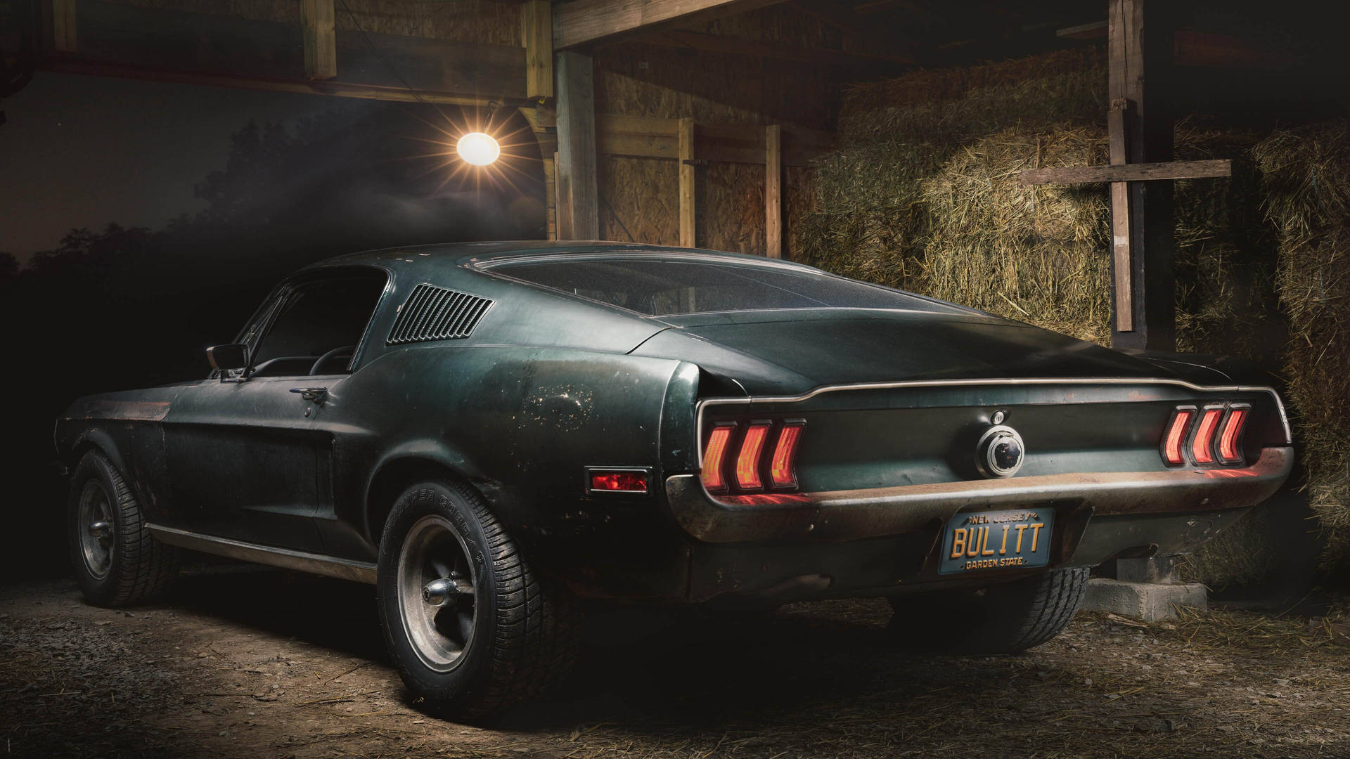 A classic Ford Mustang, possibly a Bullitt edition, parked in a rustic barn, exuding vintage charm and power