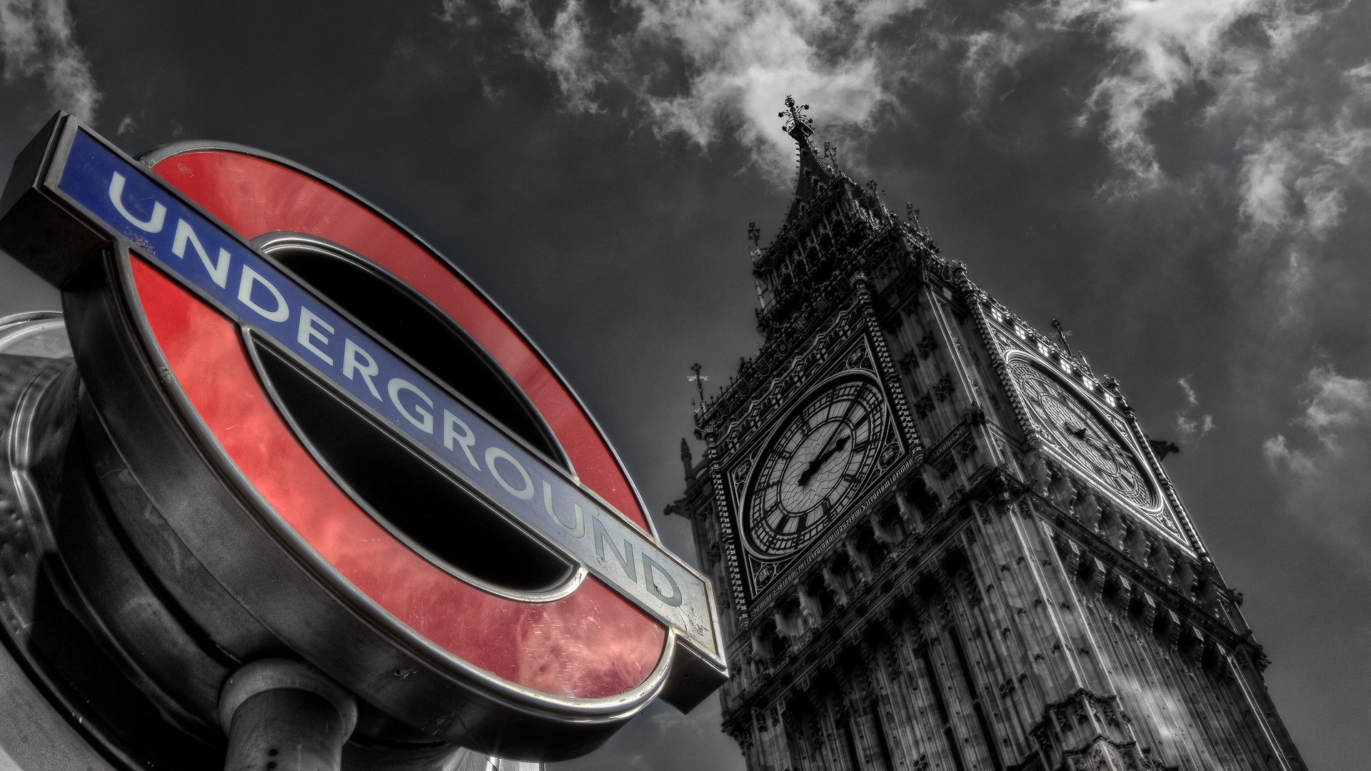 A striking black and white image of the Elizabeth Tower (Big Ben) juxtaposed with the iconic red and blue London Underground sign