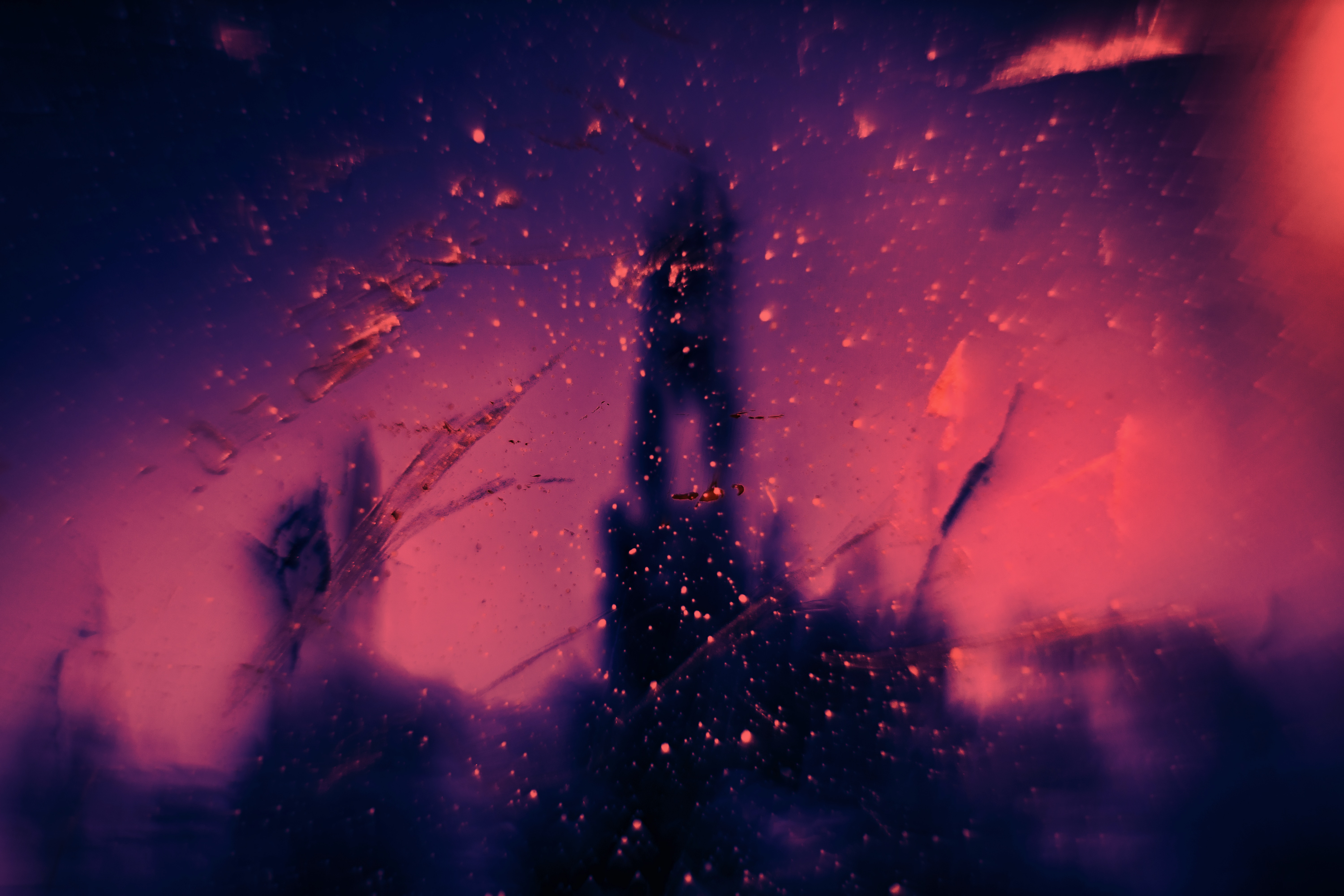 Abstract image of a blurred tower silhouette against a vibrant pink and purple backdrop, with light flares and bokeh effects creating a dreamy, ethereal atmosphere