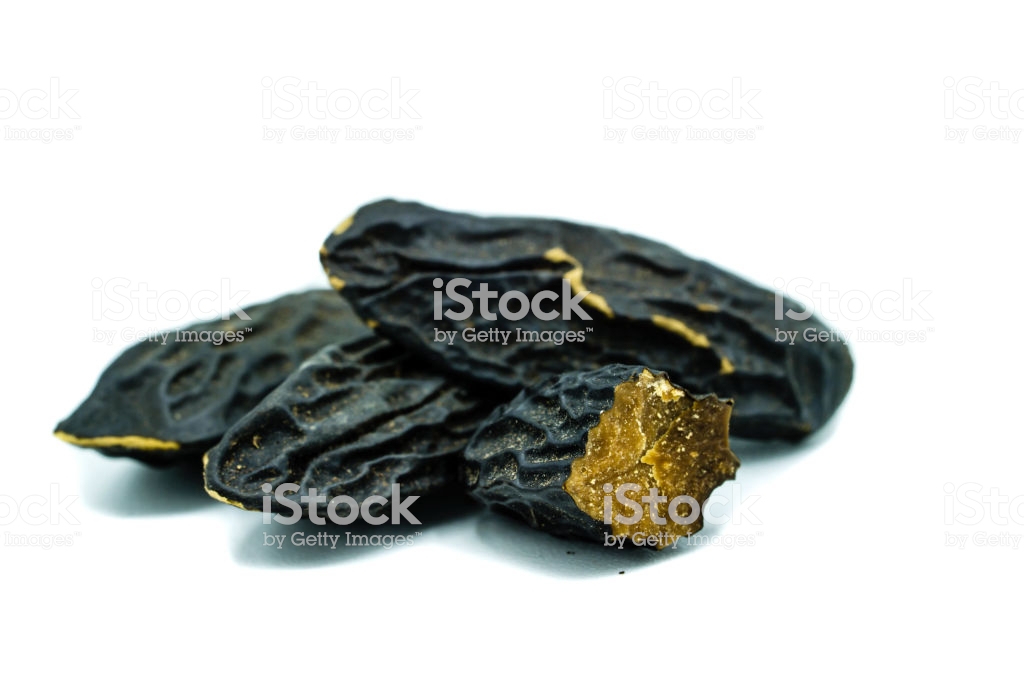 Three Whole Tonka Beans And One Cut Open Isolated On White