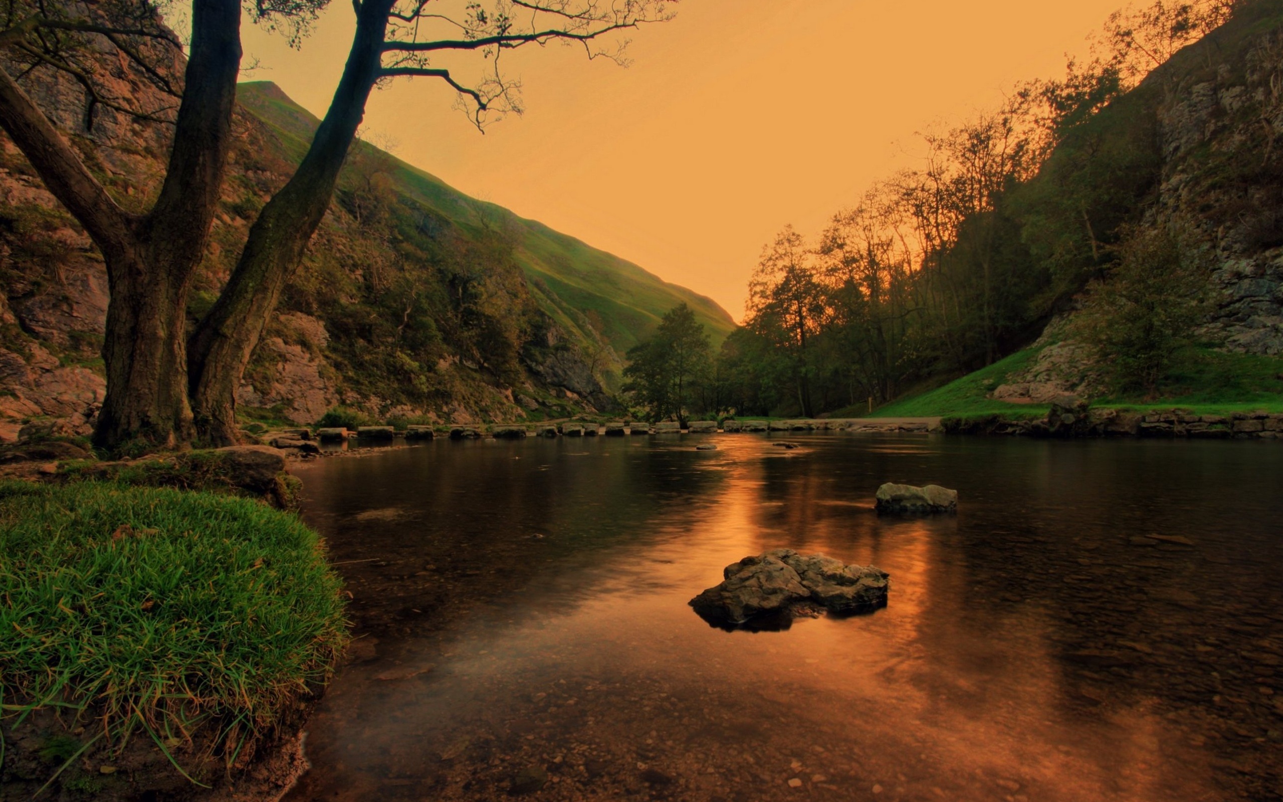Serene Sunset Landscape with River and Stepping Stones
