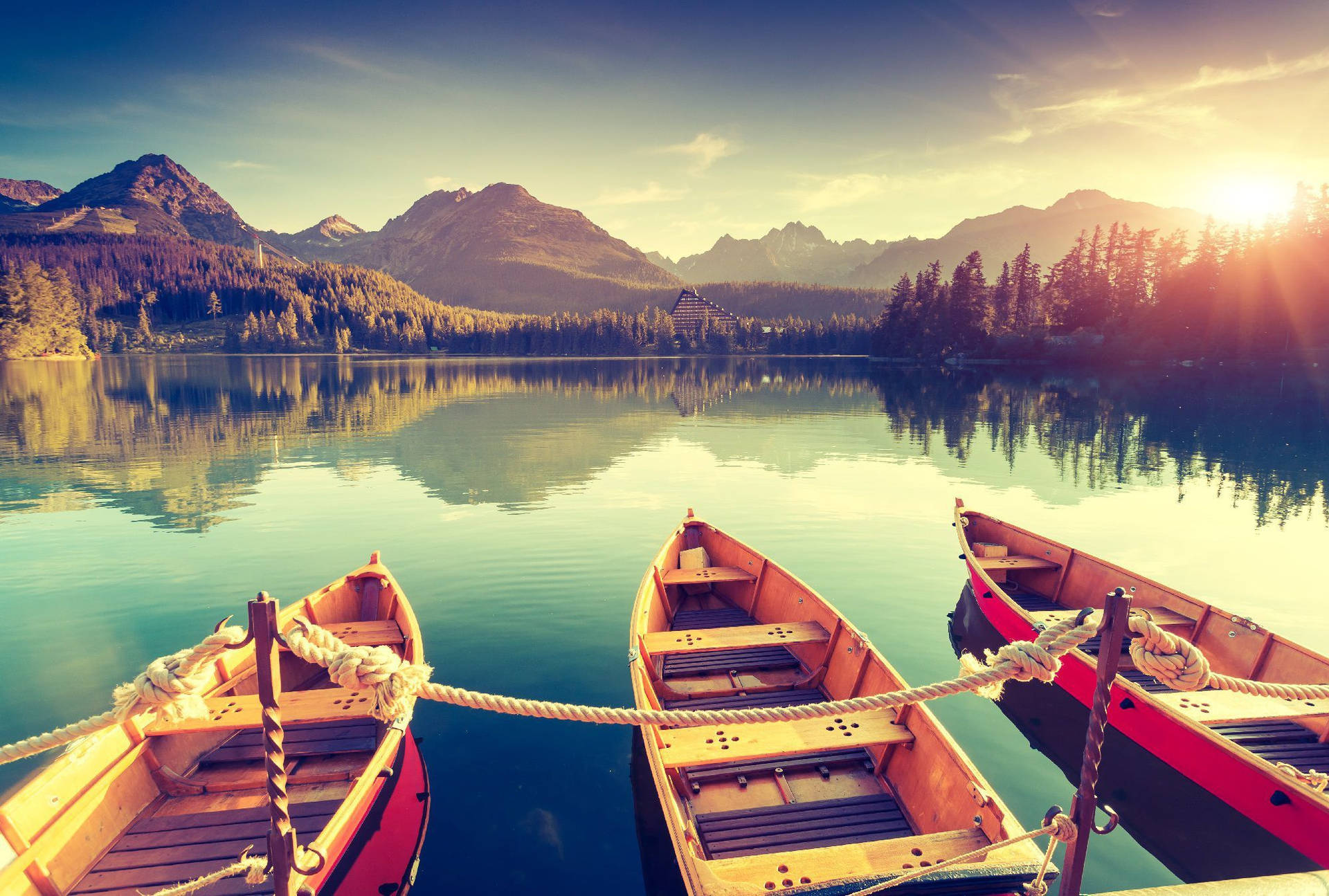 Serene Lake with Wooden Boats and Mountain View at Sunrise