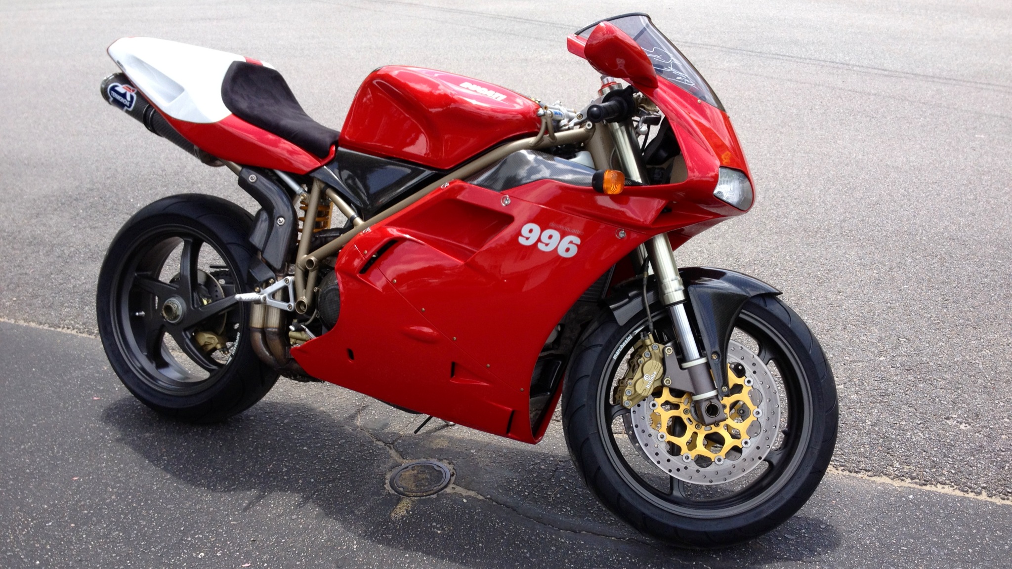 Ducati 996 sportbike parked on asphalt, showcasing its red and white design